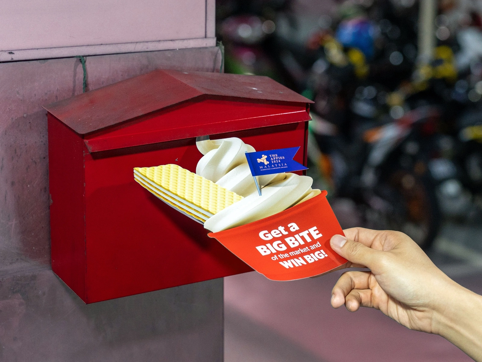 Pos Malaysia staff putting a direct mailer into a mailbox.